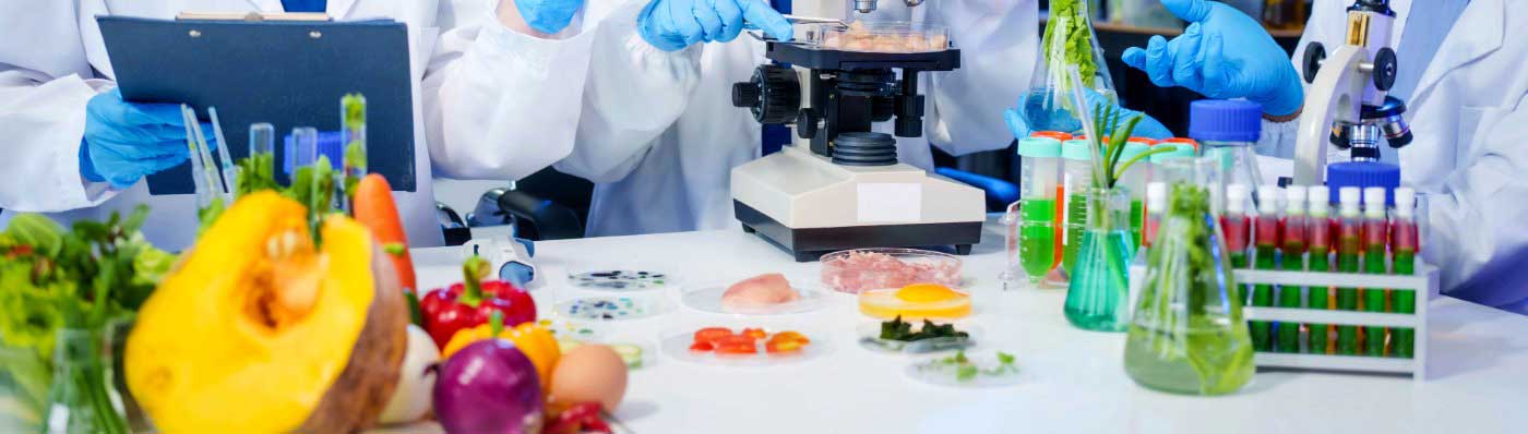 Imagen de laboratorio analizando alimentos, con relación a riesgos emergentes alimentarios