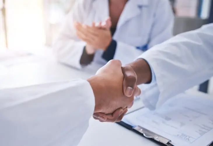 pharmaceutical professionals representing a CDMO and CMO partnership.
