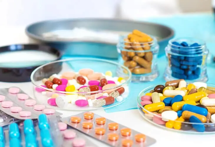 Assorted tablets and capsules in a lab, representing product development in the r&d pharmaceutical industry.