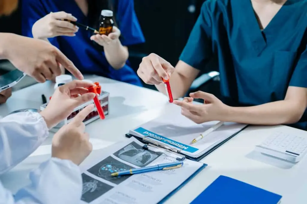 Team of tissue engineering researchers analyzing test tubes during the development and validation of biological scaffolds for cell regeneration.